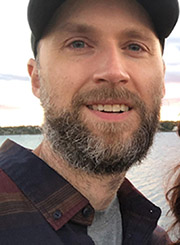 evan smiling by an ocean scene
